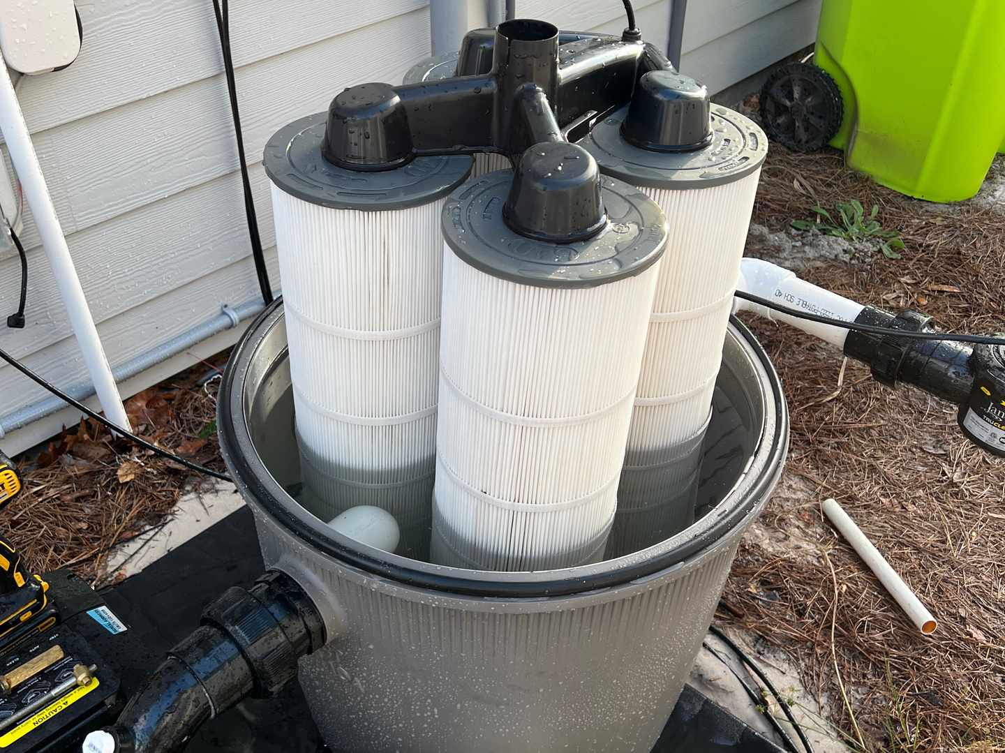 Pool cartridge filter elements laid out for inspection and cleaning at a residential pool in Oak Island, NC
